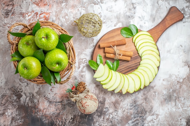 Vue de dessus de savoureuses pommes vertes avec des fruits tranchés sur un sol clair