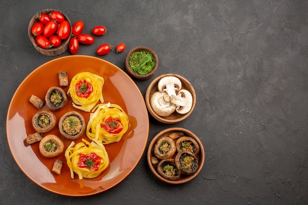 Vue de dessus savoureux champignons cuits avec des légumes sur fond sombre