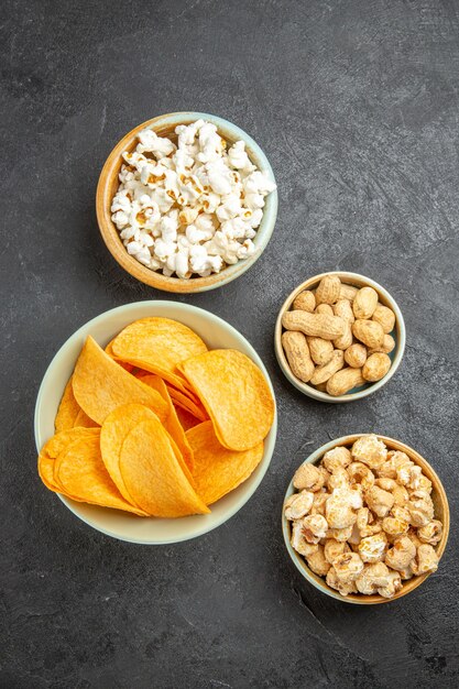 Vue de dessus de savoureux chips de fromage avec différentes collations sur le fond sombre