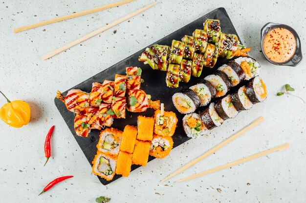 Vue de dessus de savoureux et délicieux sushis sur une planche de bois