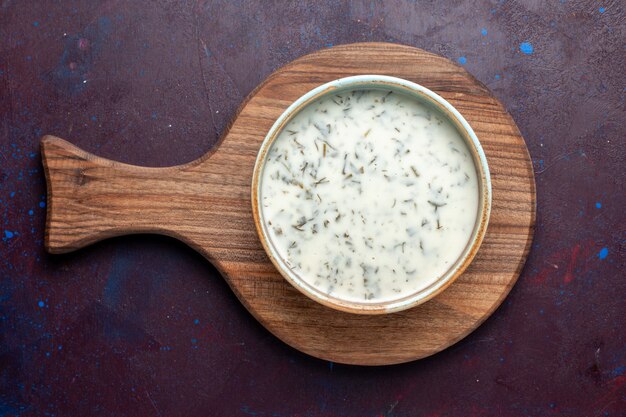 Vue de dessus savoureux dovga du yaourt avec des verts à l'intérieur sur la table sombre, soupe alimentaire repas vert