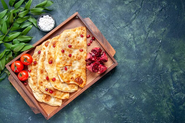 Vue de dessus de savoureux gutabs minces petits pains avec de la viande à l'intérieur du bureau sur fond sombre pâte à pain tarte couleur pâtisserie four gâteau repas