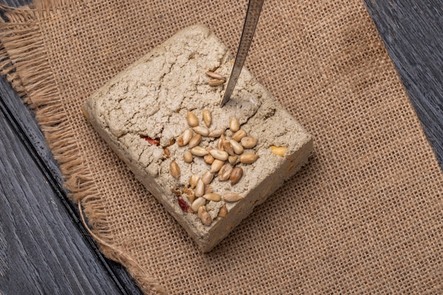 Vue de dessus de savoureux halva avec un couteau et des graines de tournesol sur un sac