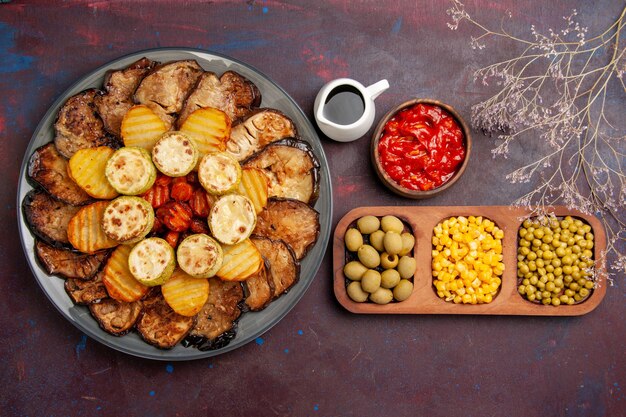 Vue de dessus de savoureux légumes cuits au four pommes de terre et aubergines sur le fond sombre repas four cuisson cuire les légumes