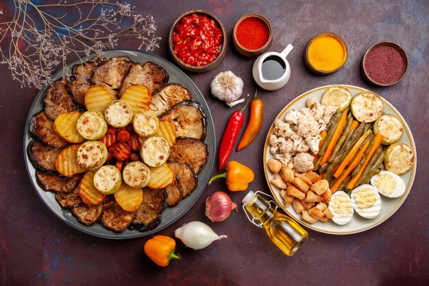 Vue de dessus de savoureux légumes cuits au four avec repas aux œufs et assaisonnements sur fond sombre repas four cuisson cuisson couleur végétale