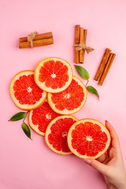 Vue De Dessus De Savoureux Pamplemousses Tranches De Fruits Juteux à La Cannelle Sur La Surface Rose