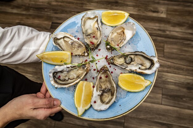 Vue de dessus d'un savoureux pétoncles au citron servi dans une assiette dans la main d'une personne