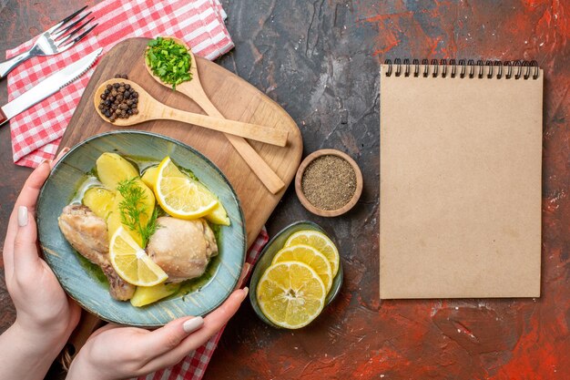 Vue de dessus savoureux poulet bouilli avec pommes de terre cuites et citron sur un fond sombre couleur de l'huile sauce alimentaire plat de viande calorie photo dîner cuisine