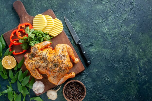 Vue de dessus savoureux poulet cuit épicé avec des pommes de terre sur le fond sombre plat de couleur de viande repas dîner restaurant barbecue nourriture