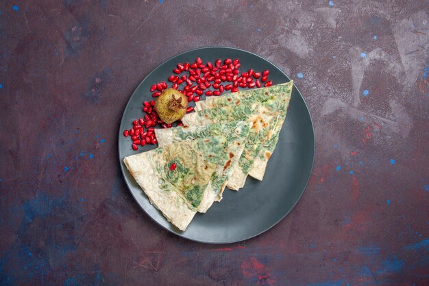 Vue de dessus savoureux qutabs cuits morceaux de pâte avec des verts à l'intérieur sur fond noir