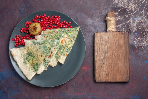 Vue de dessus savoureux qutabs cuits morceaux de pâte avec des verts à l'intérieur sur fond noir