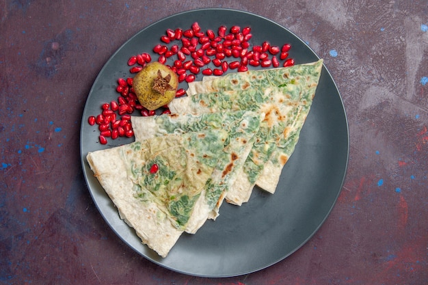 Vue de dessus savoureux qutabs cuits morceaux de pâte avec des verts à l'intérieur sur fond noir