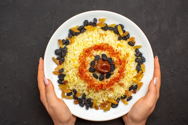 Photo gratuit vue de dessus savoureux repas oriental célèbre se compose de riz cuit et de différents raisins secs sur l'obscurité