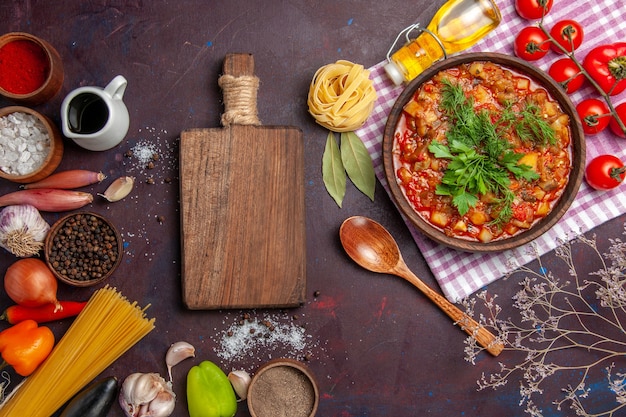 Vue de dessus savoureux repas de sauce aux légumes cuits avec des tomates et des assaisonnements sur fond sombre plat de sauce repas nourriture