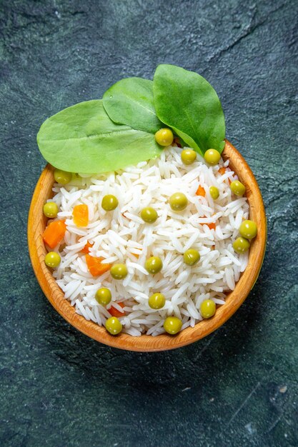 Vue de dessus savoureux riz bouilli avec des haricots verts à l'intérieur de la petite assiette sur un bureau sombre