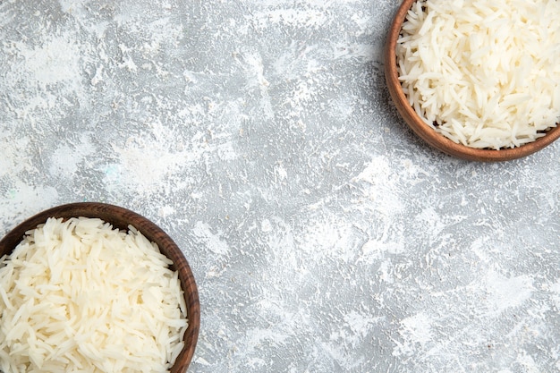 Photo gratuite vue de dessus savoureux riz cuit à l'intérieur des assiettes brunes sur le blanc