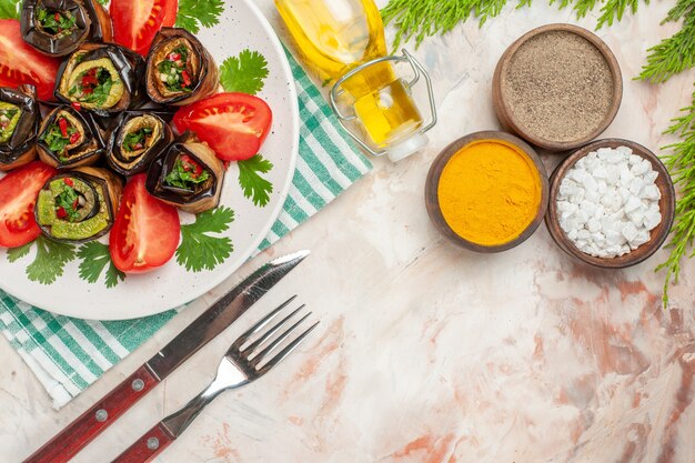 Vue de dessus de savoureux rouleaux d'aubergines avec assaisonnements tomates et verts