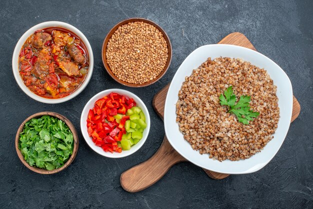 Vue de dessus savoureux sarrasin cuit avec soupe de légumes verts et légumes sur gris