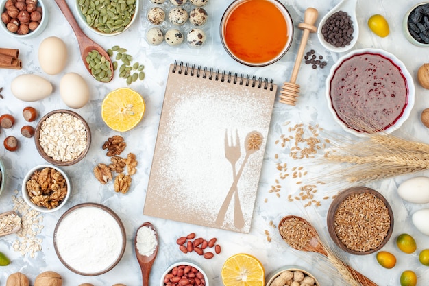 Vue de dessus simple bloc-notes avec de la gelée de farine d'oeufs et différentes noix sur une tarte de couleur sucre aux noix blanches pâte photo gâteau sucré aux fruits