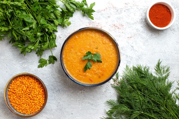 Vue de dessus de la soupe aux haricots appelée merci à l'intérieur de la petite assiette avec des verts sur la surface blanche soupe repas alimentaire haricot végétal