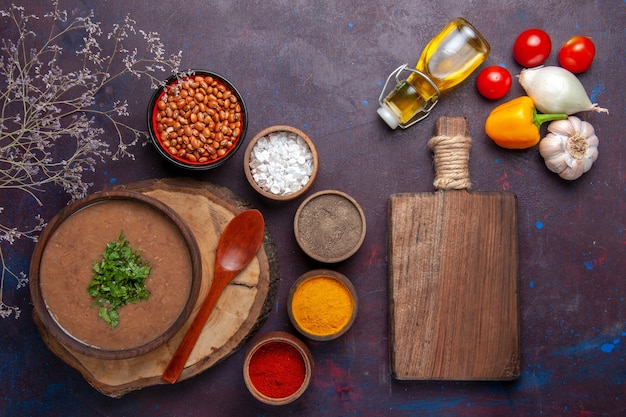 Vue de dessus soupe aux haricots bruns délicieuse soupe cuite avec différents assaisonnements sur une surface sombre dîner soupe aux haricots repas