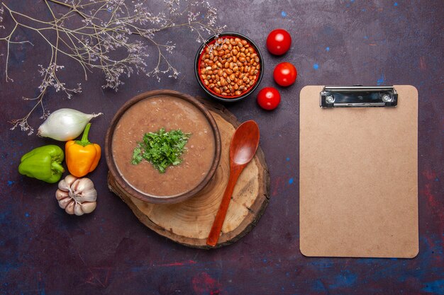 Vue de dessus soupe aux haricots bruns délicieuse soupe cuite avec des légumes sur une surface sombre soupe aux légumes repas huile alimentaire