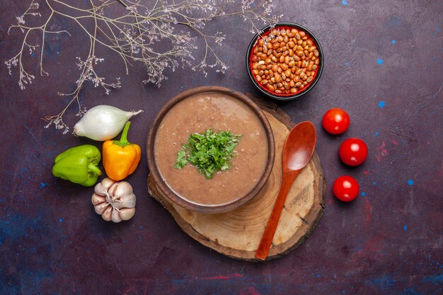 Vue de dessus soupe aux haricots bruns avec des légumes et des légumes verts sur une surface sombre soupe aux légumes repas huile alimentaire