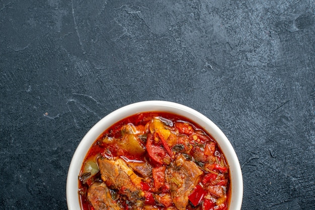 Vue de dessus soupe aux légumes avec de la viande à l'intérieur de la plaque sur gris foncé