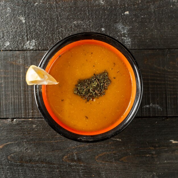 Vue de dessus de la soupe aux lentilles garnie de feuilles de menthe séchées et de citron