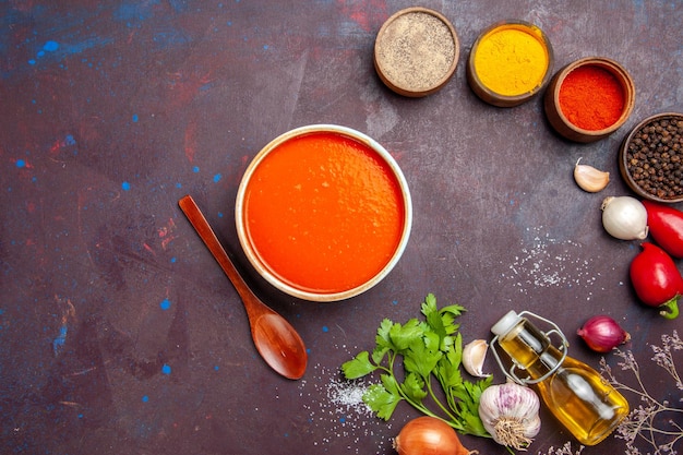 Vue de dessus de la soupe aux tomates cuites à partir de tomates fraîches avec assaisonnements sur fond noir