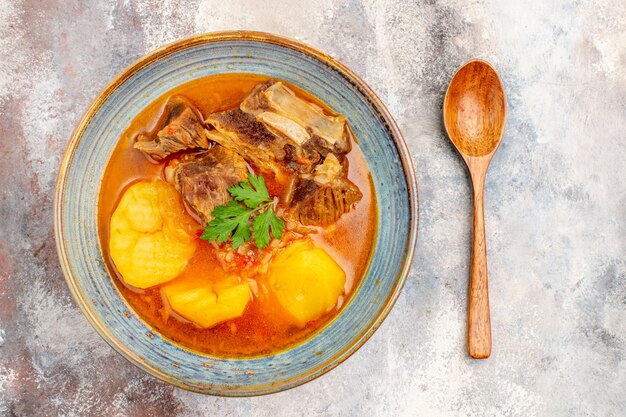 Photo gratuite vue de dessus de la soupe bozbash dans un bol une cuillère sur fond nu