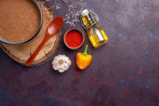 Photo gratuite vue de dessus soupe brune avec de l'huile d'olive et de l'ail sur une surface sombre soupe légumes repas cuisine haricots