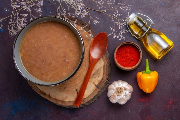 Photo gratuite vue de dessus soupe brune avec de l'huile d'olive et de l'ail sur une surface sombre soupe repas de légumes nourriture cuisine