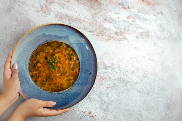 Vue de dessus soupe de légumes chauds à l'intérieur de la plaque sur l'espace blanc clair