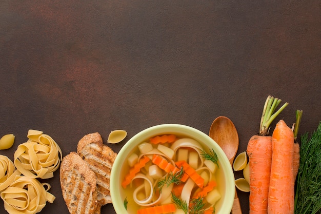 Vue de dessus de la soupe de légumes d'hiver dans un bol avec du pain grillé et des tagliatelles