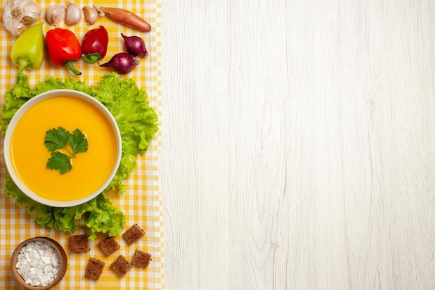 Vue de dessus de la soupe de potiron aux légumes sur blanc