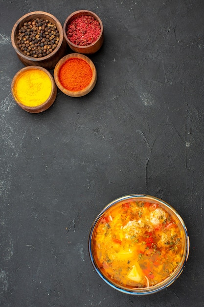 Vue de dessus soupe savoureuse avec différents assaisonnements sur le bureau gris soupe repas nourriture assaisonnement de viande épicé