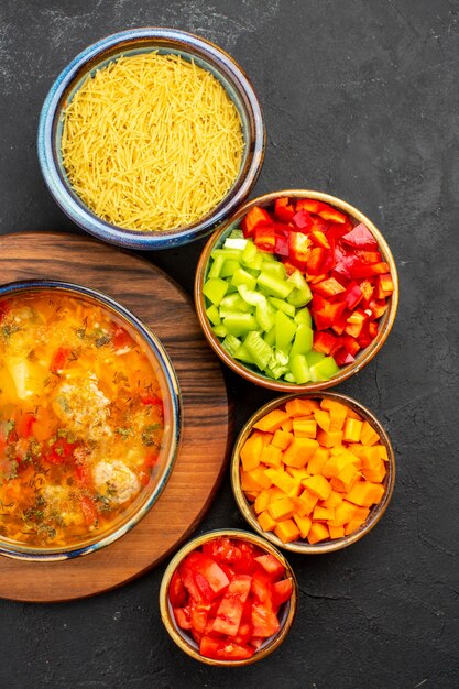 Vue de dessus soupe savoureuse avec des tranches de poivre sur fond gris soupe repas assaisonnements de viande épicé