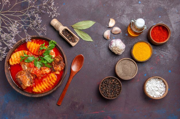 Vue de dessus soupe de viande savoureuse avec différents assaisonnements sur fond noir