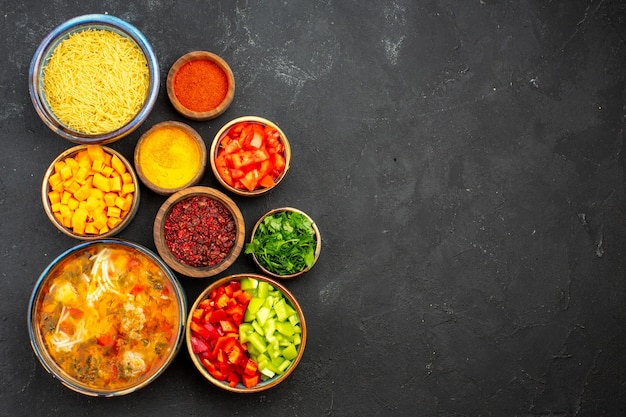 Vue de dessus soupe de viande savoureuse avec des légumes et des assaisonnements sur le fond gris salade soupe repas repas dîner alimentaire