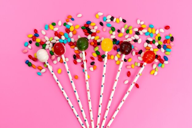 Une vue de dessus sucettes colorées avec des bonbons colorés sur rose, sucre sucré de couleur