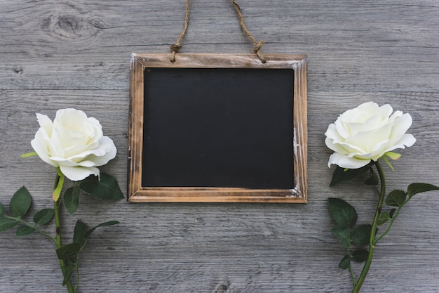 Photo gratuite vue de dessus de la surface en bois avec des fleurs et de l'ardoise