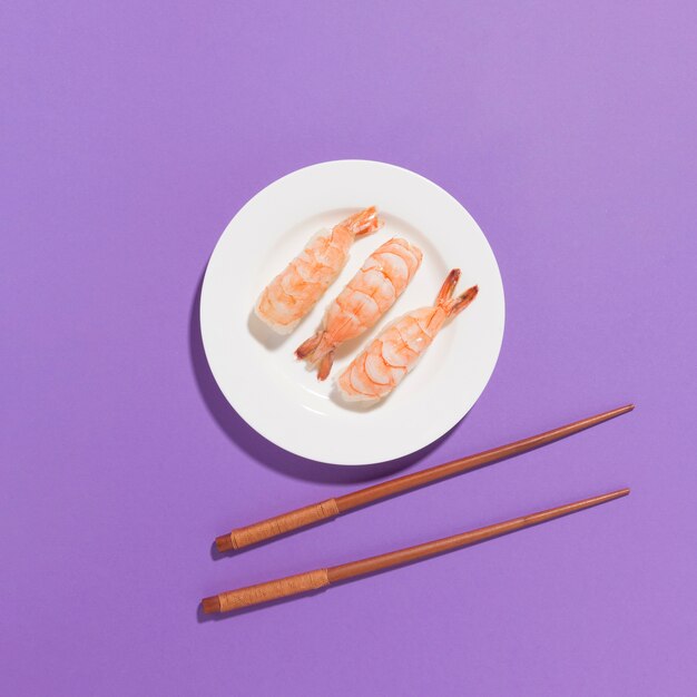 Vue de dessus des sushis frais avec des baguettes sur la table