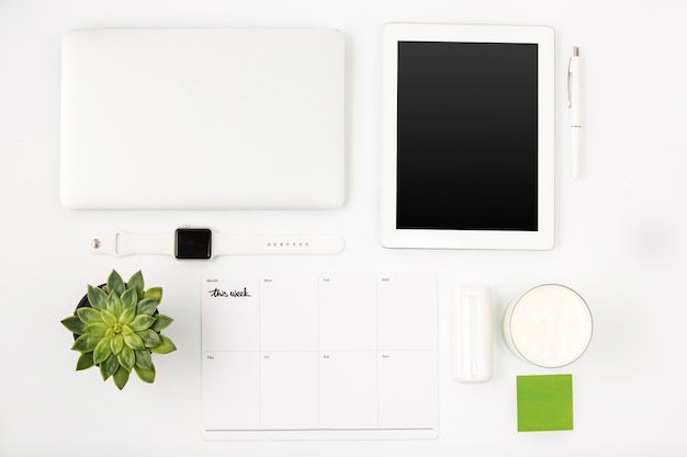 Vue de dessus de la table de bureau blanche avec ordinateur portable