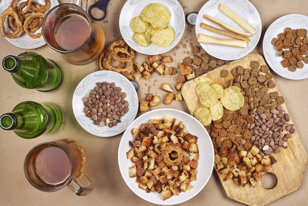 Vue de dessus d'une table de fête pleine de collations et de bière