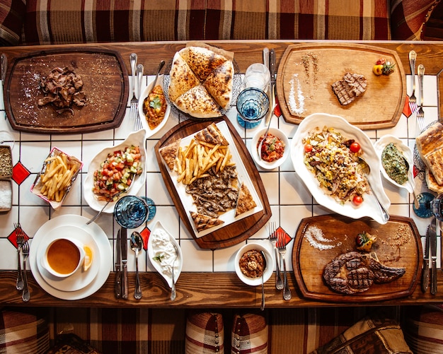 Photo gratuite vue de dessus, table servie avec plusieurs repas et collations