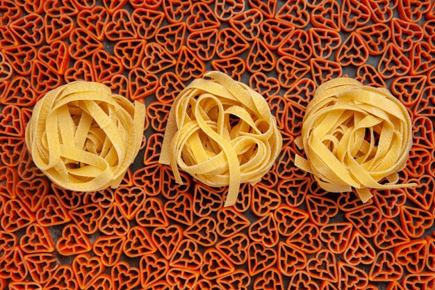 Vue de dessus des tagliatelles sur des pâtes italiennes en forme de coeur sur une table sombre