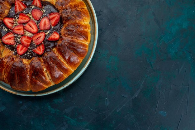 Vue de dessus de la tarte aux fraises avec de la confiture et des fraises fraîches sur un bureau bleu