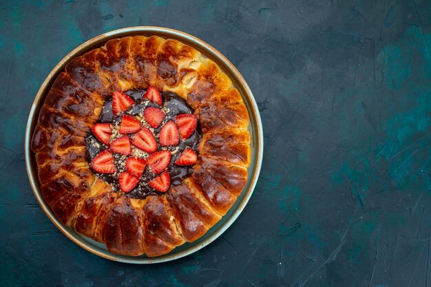 Vue de dessus de la tarte aux fraises avec de la confiture et des fraises rouges fraîches sur la surface bleue