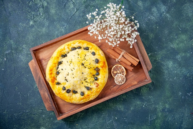 Vue de dessus tarte sucrée à l'intérieur d'un bureau en bois sur fond bleu foncé tarte aux fruits cuire au four gâteau pâtisserie biscuit dessert hotcake